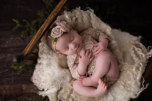 Newborn girl in lace outfit on blanket