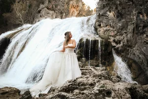 Bride in flowing dress by waterfall at DFW wedding