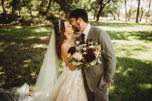 Kissing couple with bouquet at DFW wedding